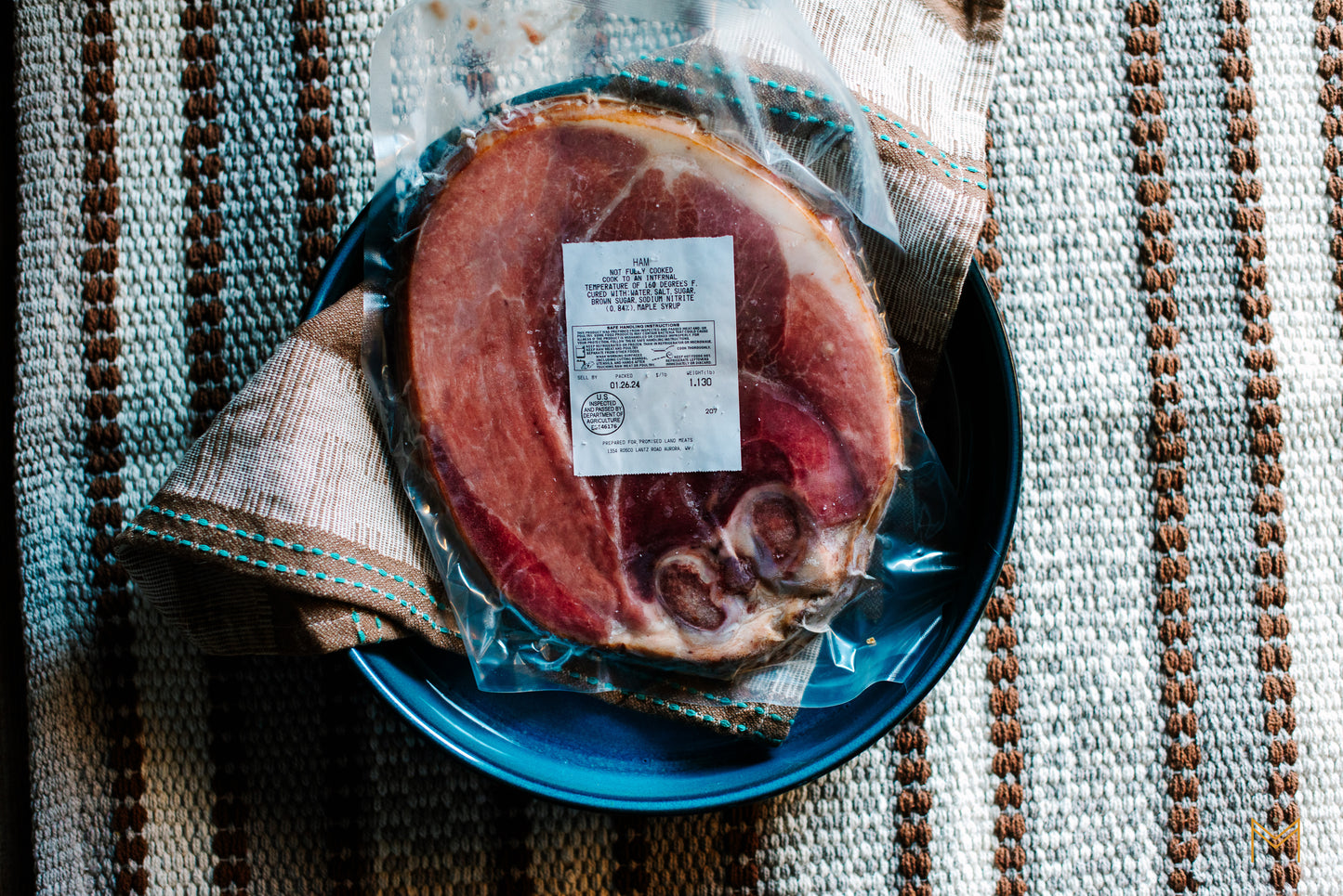 Sliced ham served on a rustic platter with fresh herbs and seasonal sides.