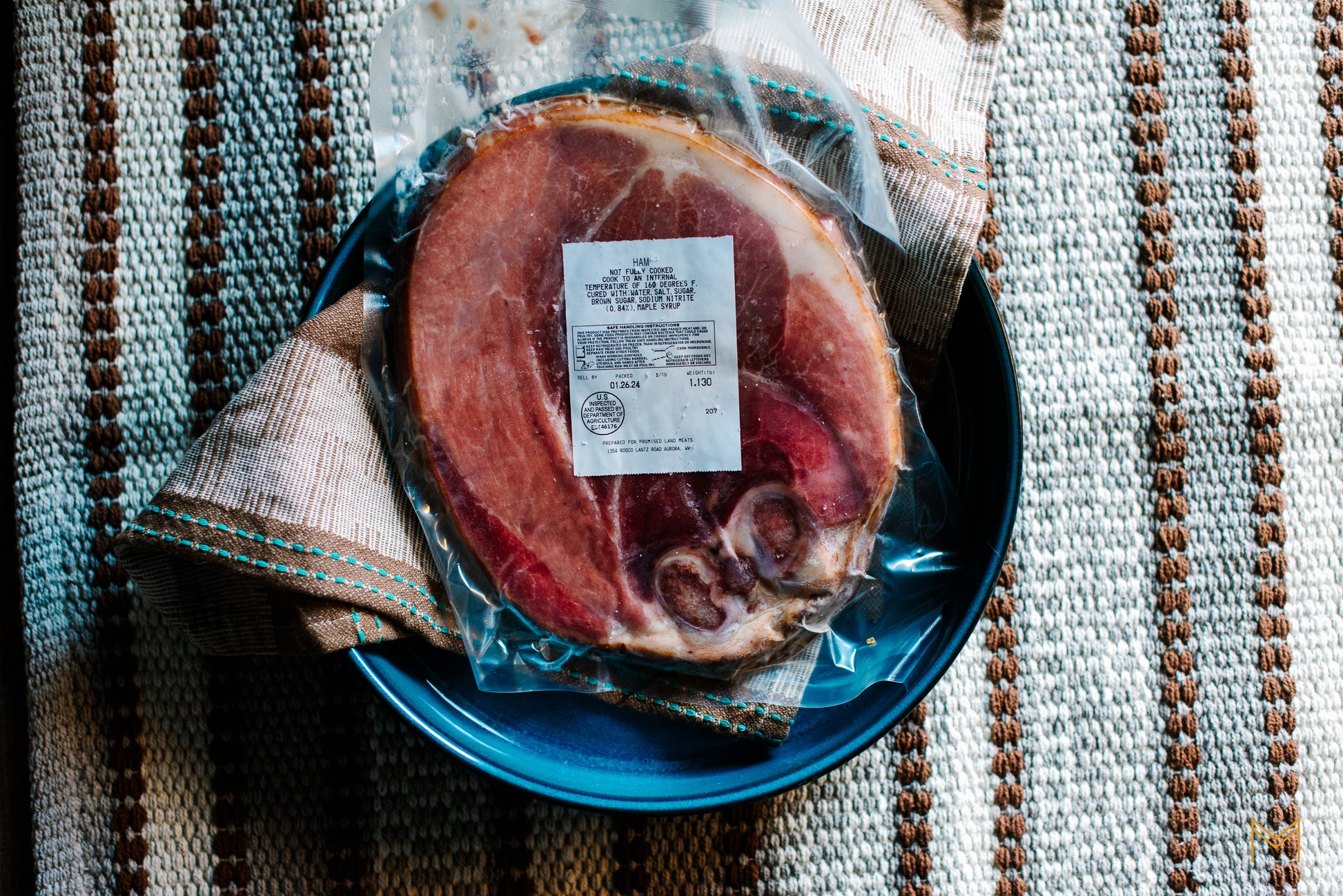 Sliced ham served on a rustic platter with fresh herbs and seasonal sides.
