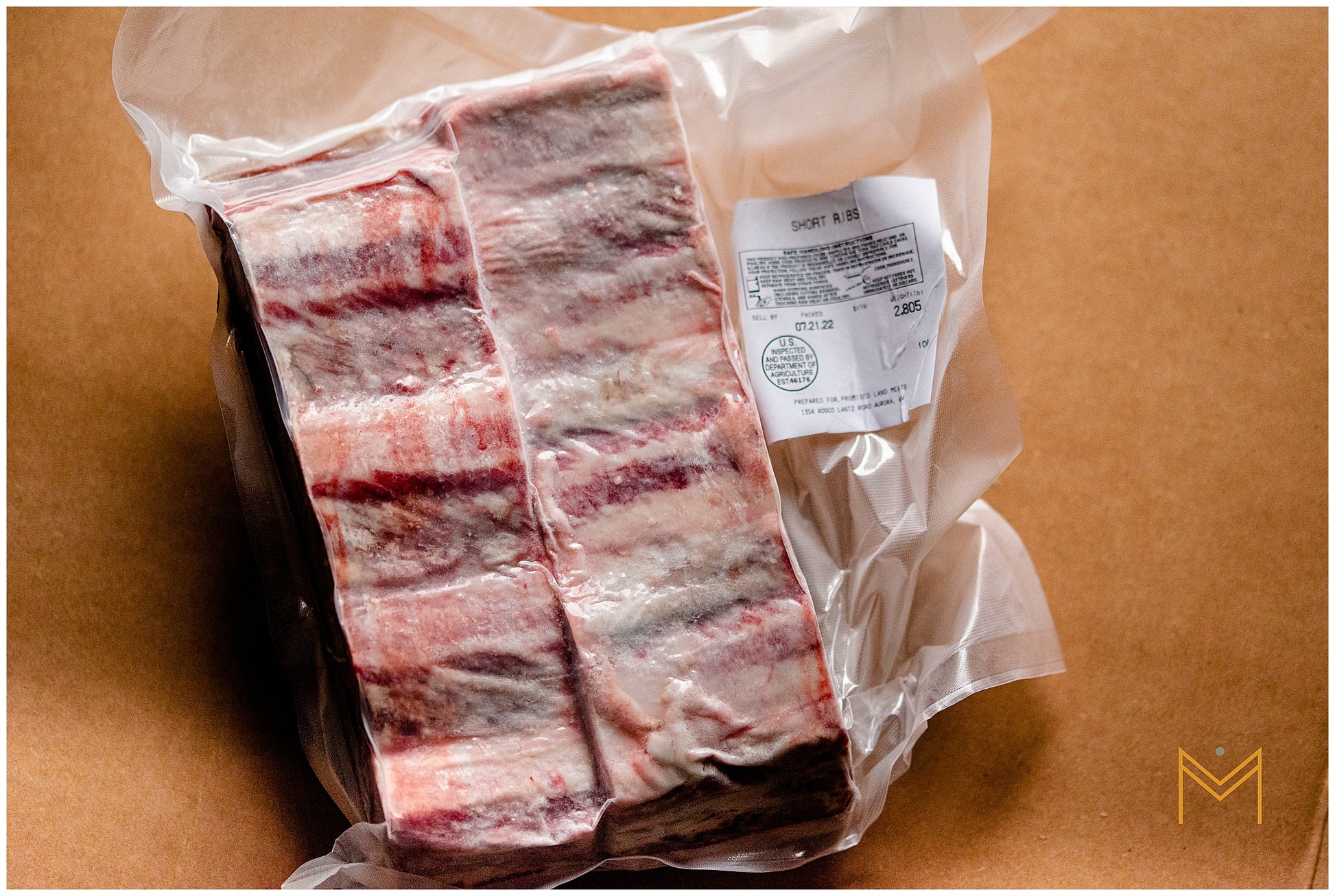 Packaged beef short ribs on a plain background.