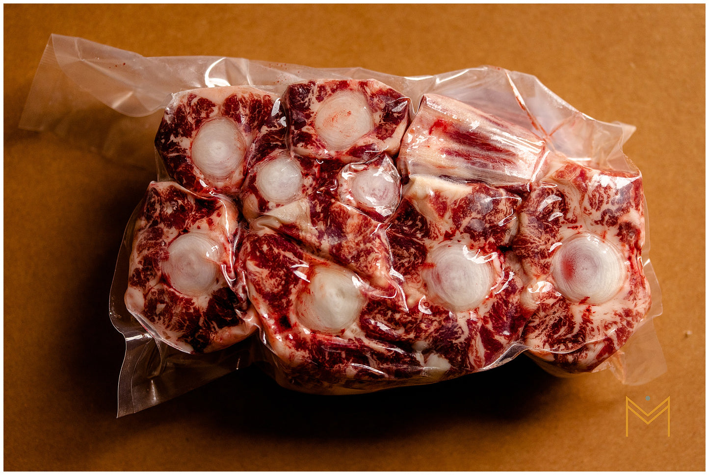 Packaged oxtail meat on a brown surface.