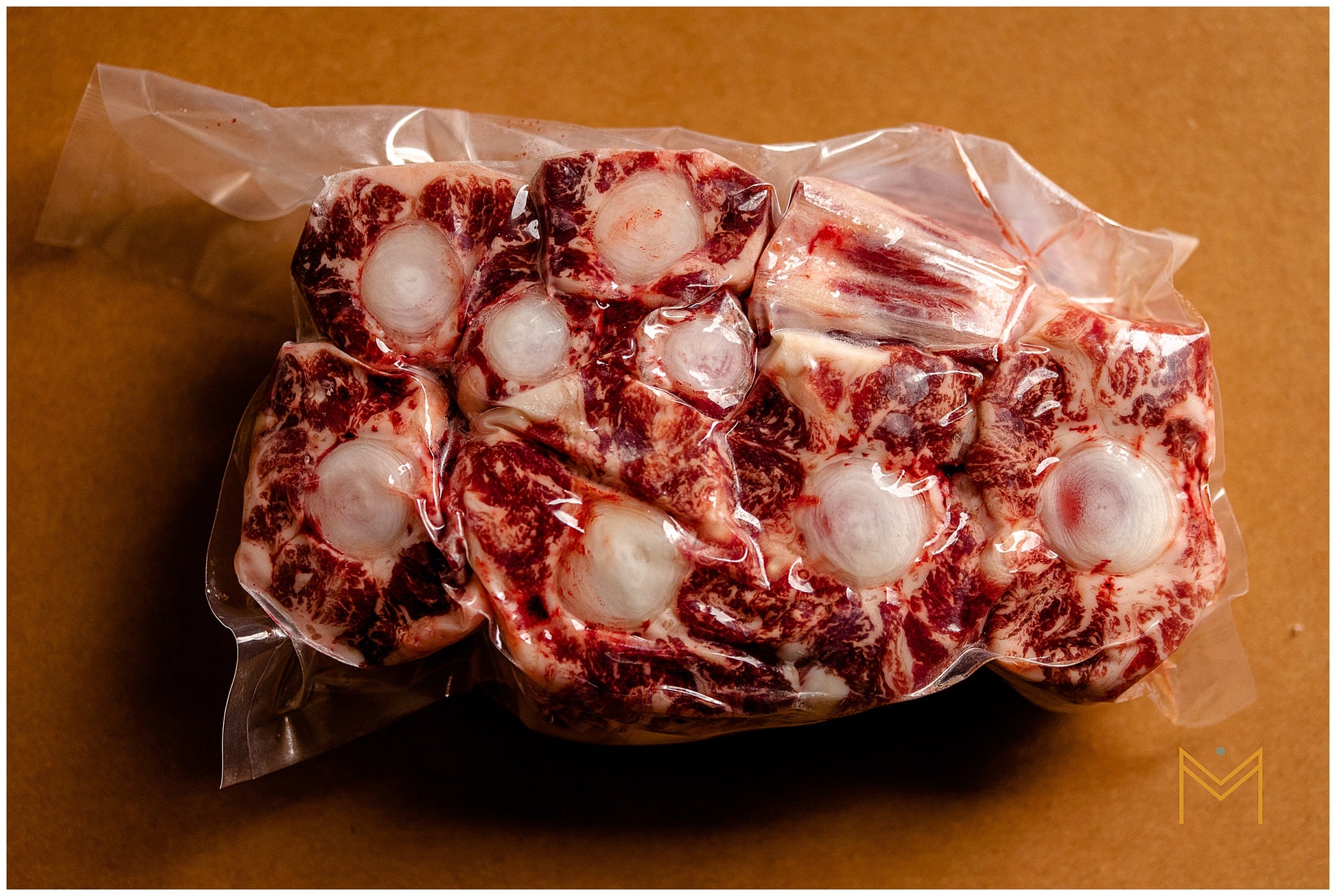 Packaged oxtail meat on a brown surface.